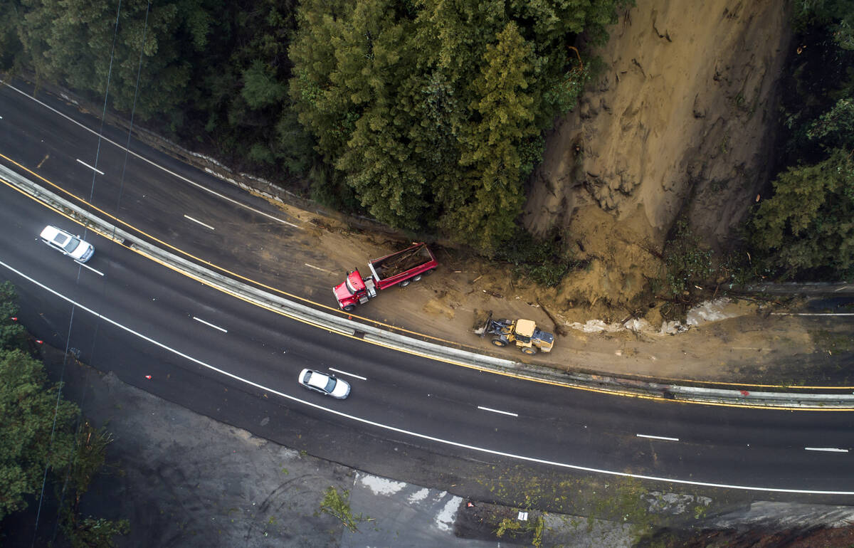 Caltrans crews work to clear a mudslide on Highway 17 that resulted from heavy rain from an atm ...