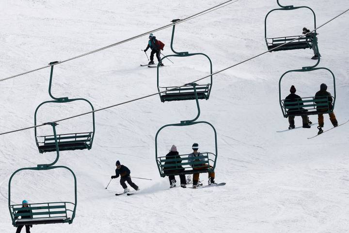 Skiers and snowboarders enjoy the slope as people ride chairlifts Monday, Dec. 26, 2022, at the ...