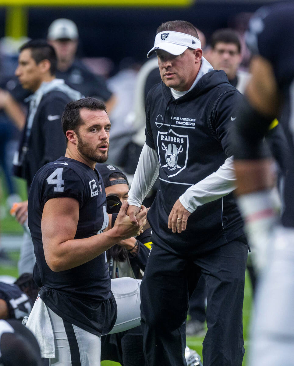 Raiders Head Coach Josh McDaniels talks with quarterback Derek Carr (4) during warm ups before ...