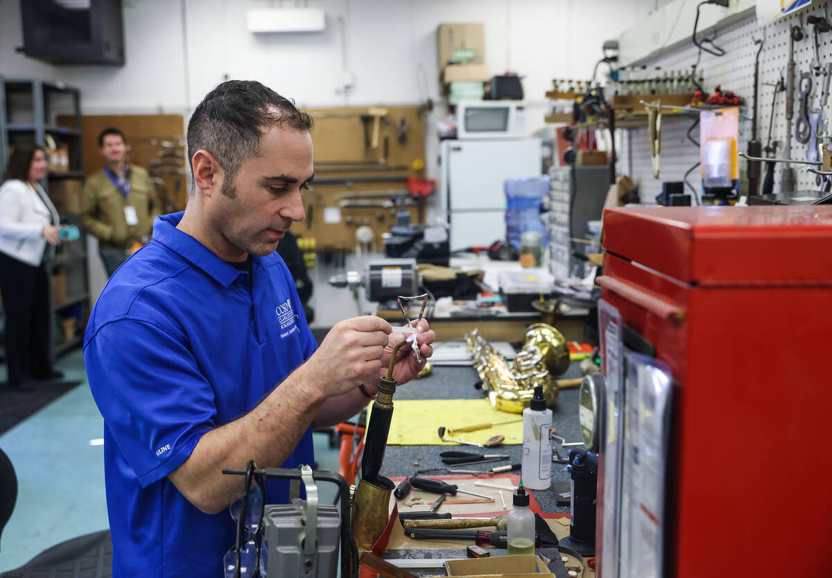 Tim Adelson, a musical instrument repair technician for the Clark County School District, repai ...
