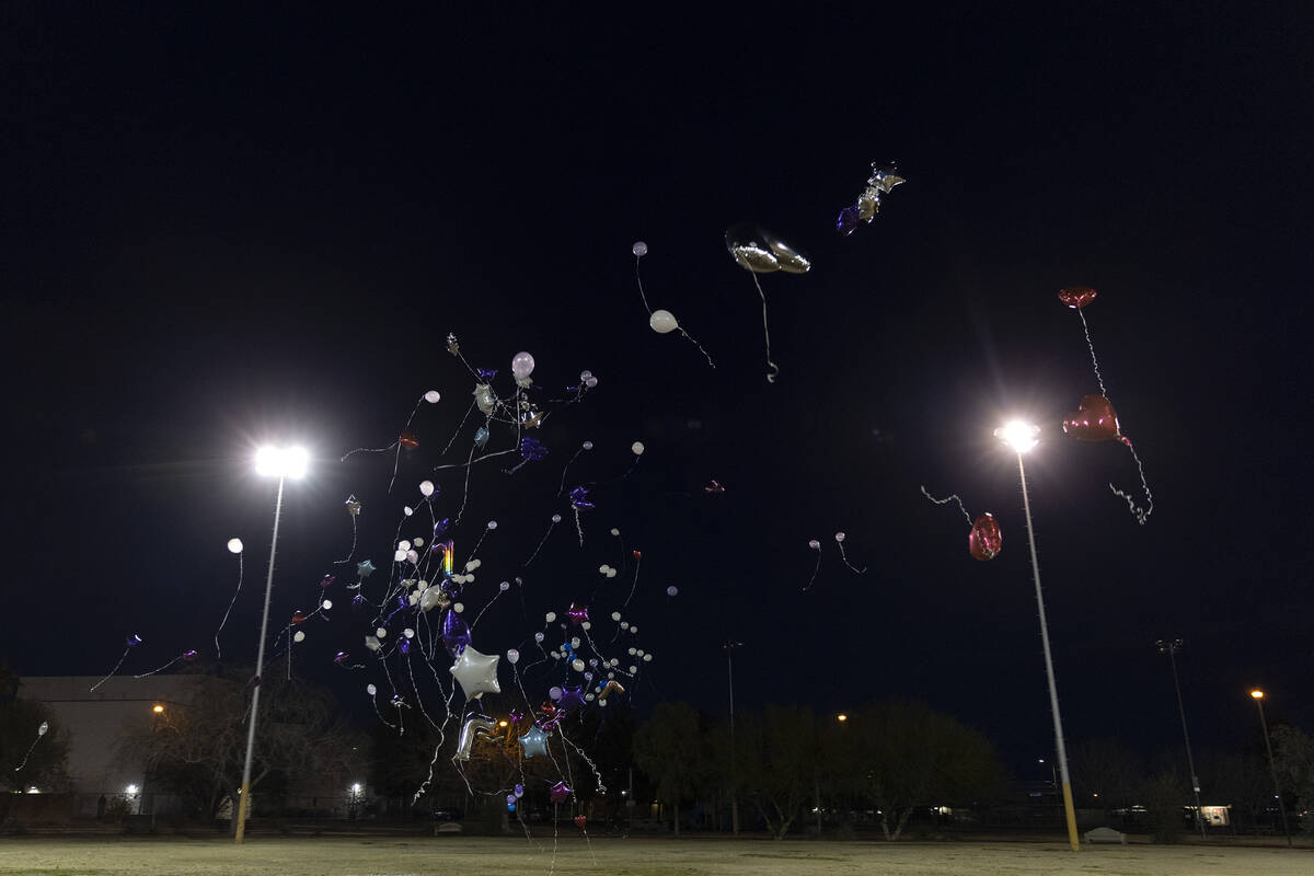 Balloons, released in honor of Ashari Hughes, fly into the night sky outside Doolittle Communit ...