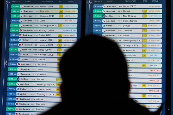 A display shows flights, many delayed, at LaGuardia Airport in New York, Wednesday, Jan. 11, 20 ...