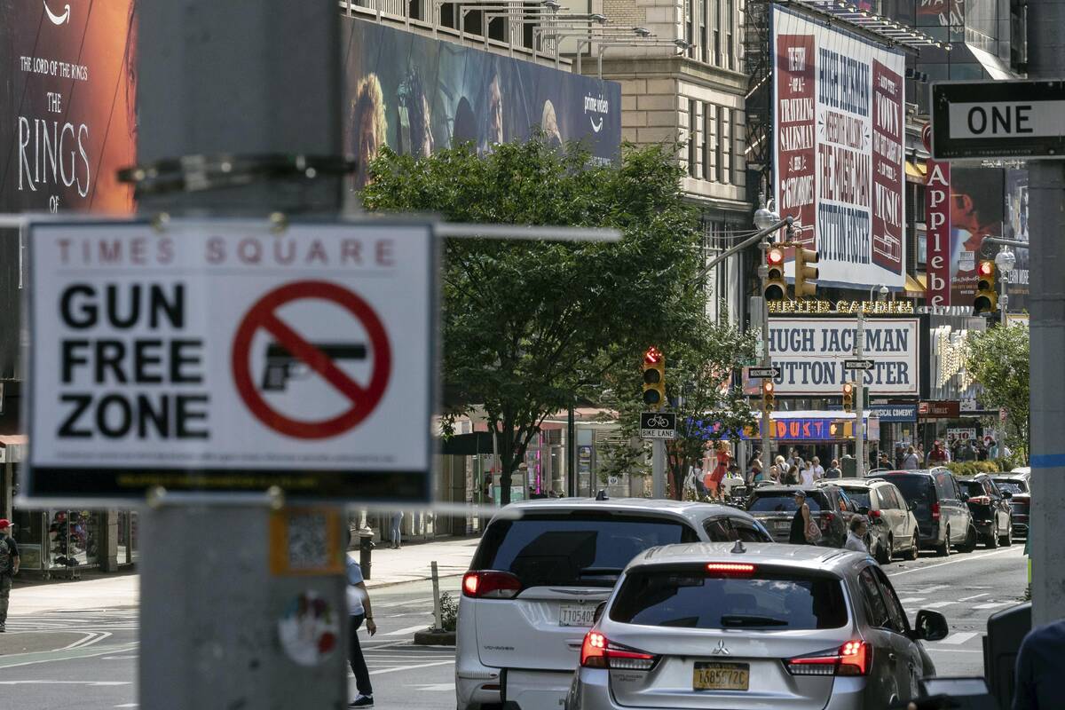 FILE - A sign reading "Gun Free Zone" is posted near around Times Square, Aug. 31, 20 ...