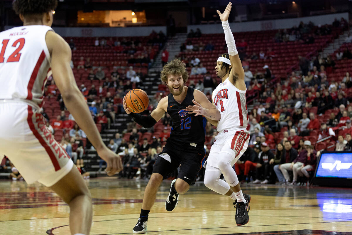 Boise State Broncos guard Max Rice (12) drives around UNLV Rebels guard Justin Webster (2) duri ...
