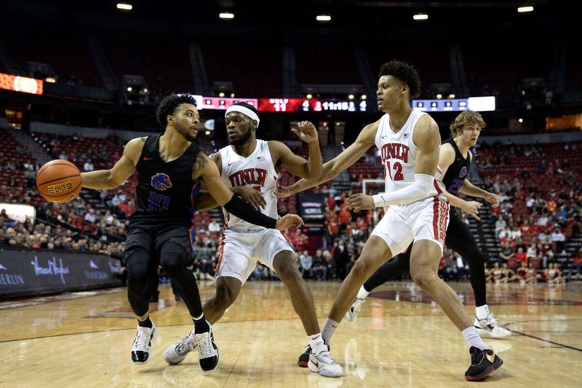 UNLV Rebels guard EJ Harkless, center, and center David Muoka (12) defend against Boise State B ...