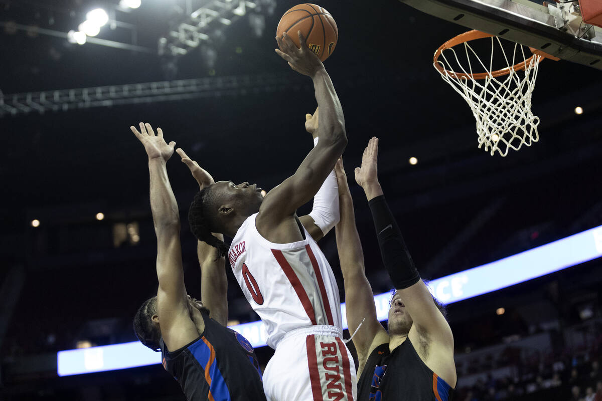 UNLV Rebels forward Victor Iwuakor, center, shoots against Boise State Broncos guard Chibuzo Ag ...