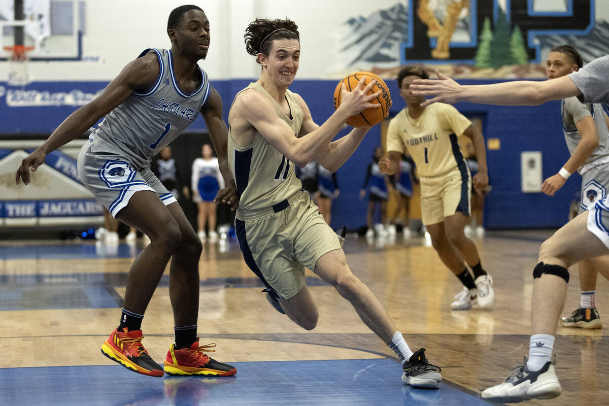 Foothill’s Zakary Abdalla (11) drives around Desert Pines’ Kameron Ricks (1) duri ...