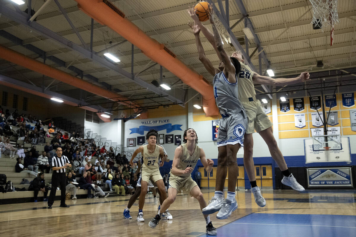 Desert Pines’ Evan Tatum (11) and Brock Stearman (20) jump for a rebound during a boys h ...