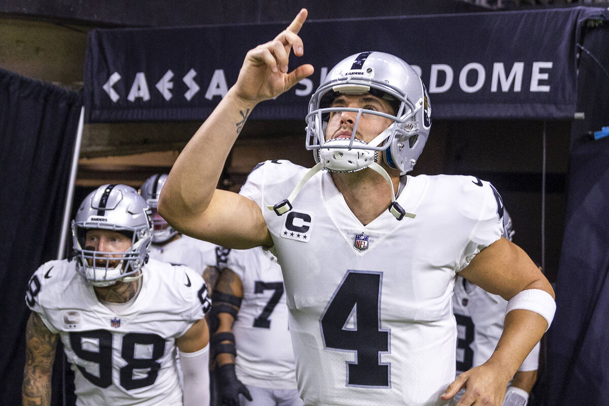 Raiders quarterback Derek Carr (4) and defensive end Maxx Crosby (98) take the field with teamm ...