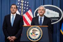 Attorney General Merrick Garland, right, speaks during a news conference at the Department of J ...