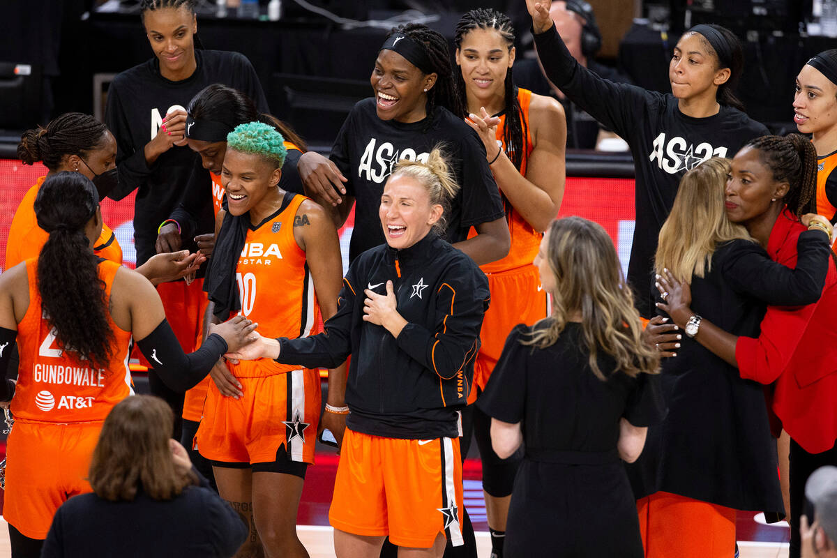 Members of Team WNBA celebrate a win against the U.S. Women's National Team as teammate Arike O ...
