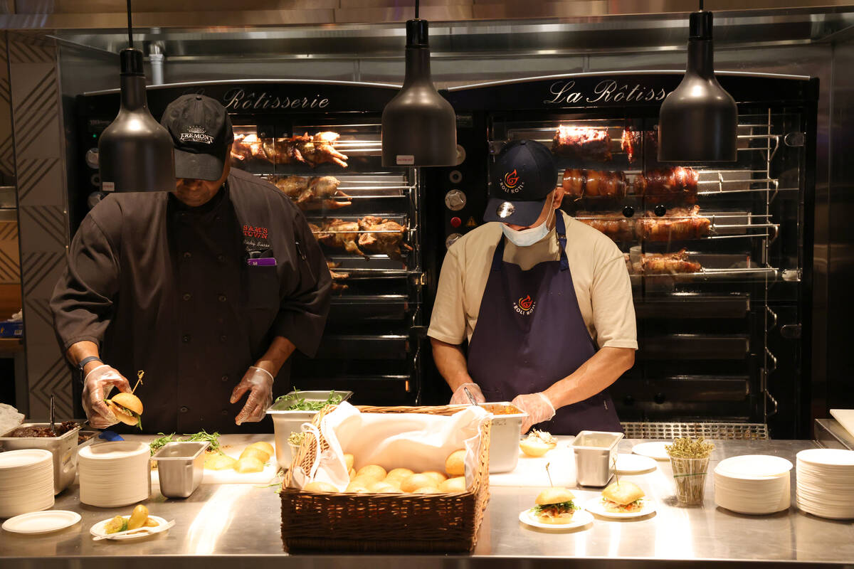 Roli Roti Gourmet Rotisserie workers prepare snack samples during the grand opening of Fremont ...