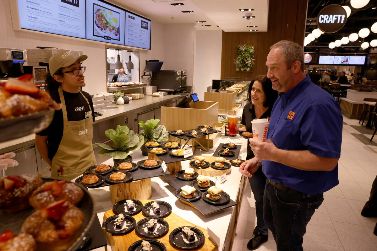 Dunkin' franchisee co-owners Nicky Hassett and Greg Novak, right, mingle with CRAFTkitchen snac ...