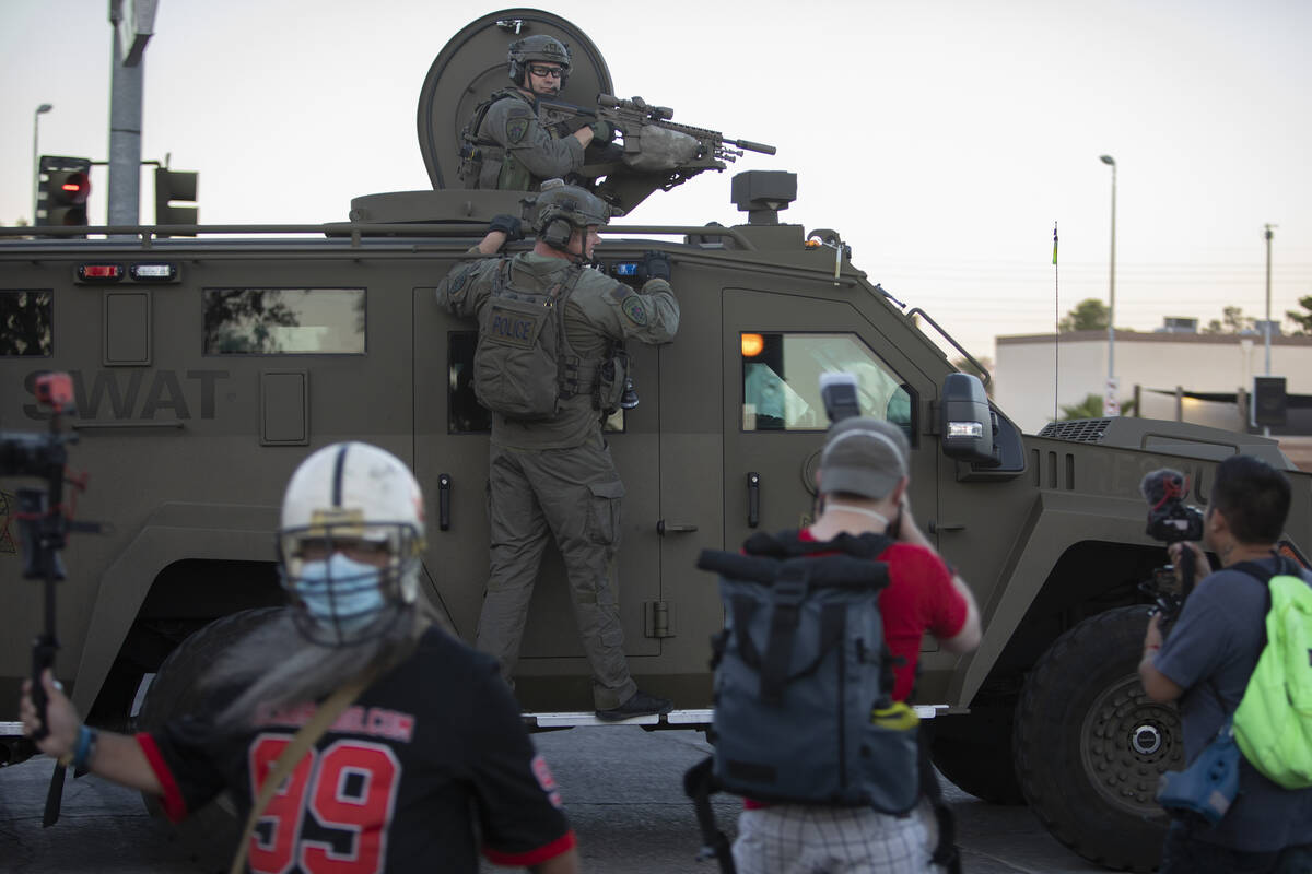 SWAT exits the Mandalay Bay Convention Center past protesters as they march up Russell Road tow ...