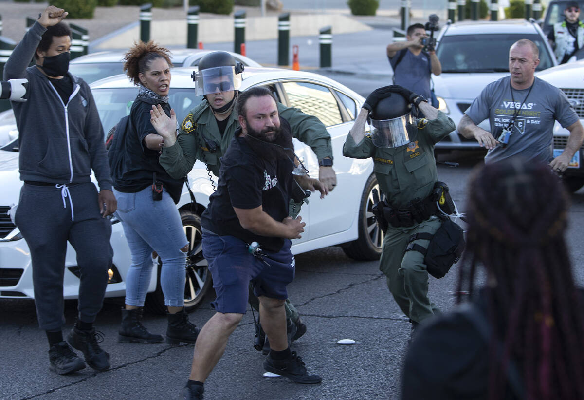 One protester breaks away as police attempt to arrest him during a march against police brutali ...