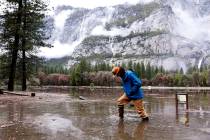 FILE - Kevin Kimo Laughlin, a maintenance worker for Aramark, wades back to dry ground as the M ...