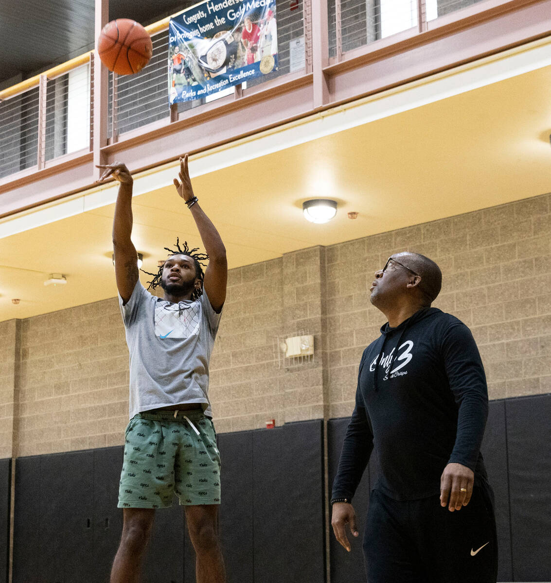 Former Coronado basketball standout Felix Reeves shoots the ball as his trainer Damion Byrd loo ...