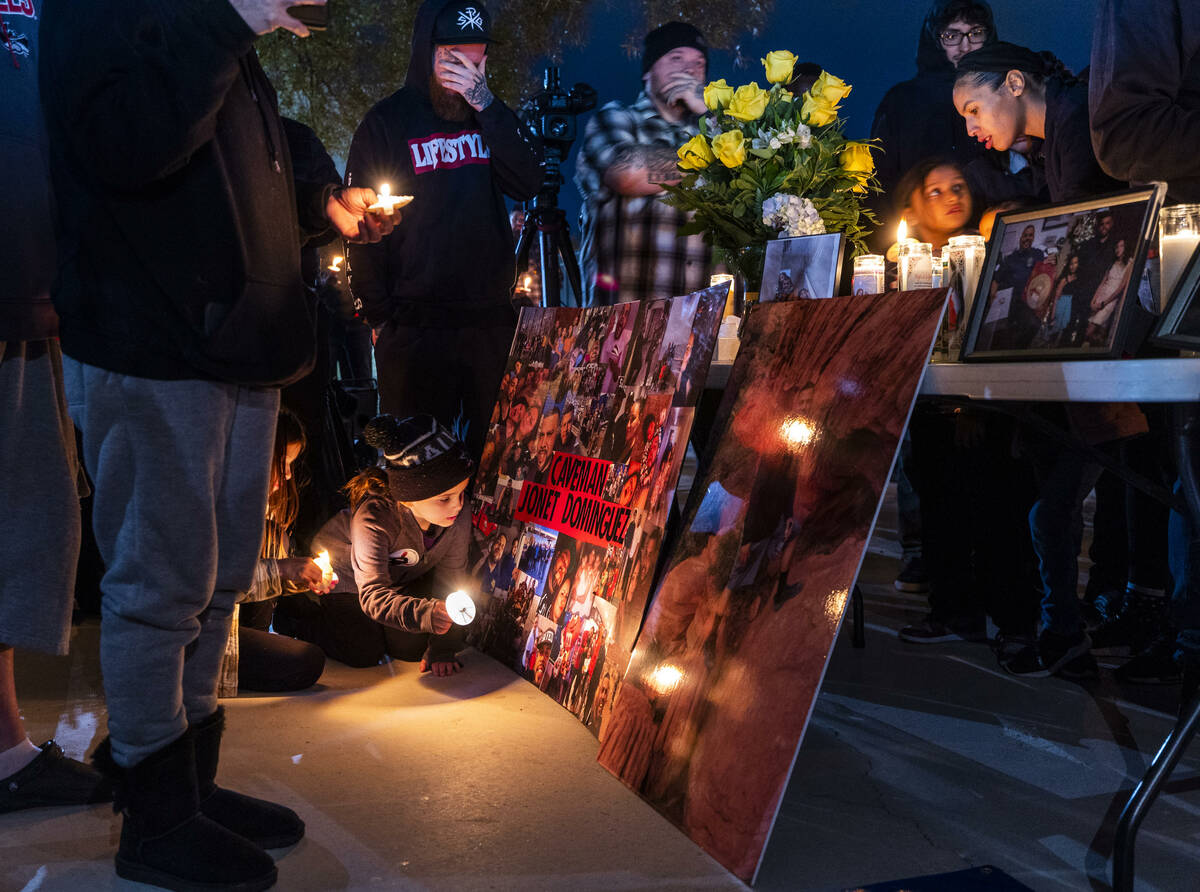 Mourners look to images of Jonet Dominguez amongst others on display during a candlelight vigil ...
