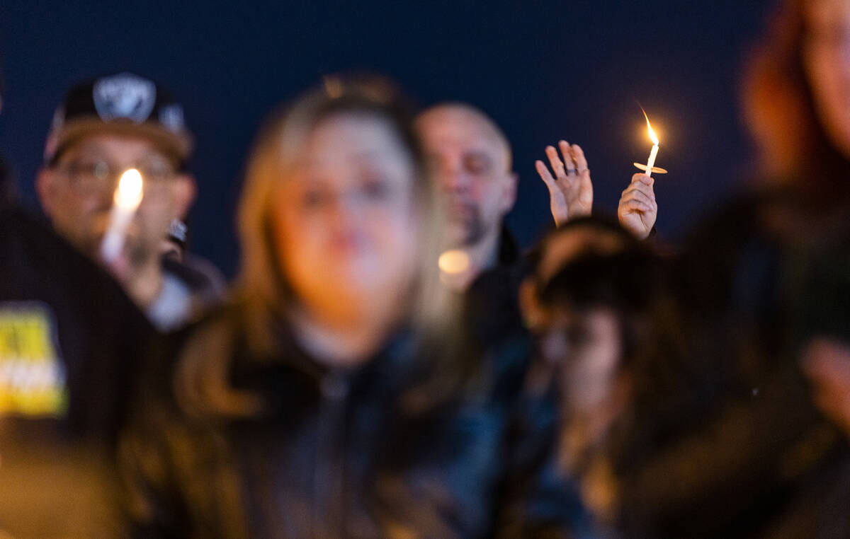 Candles are held aloft as mourners honor Jonet Dominguez during a candlelight vigil at Awaken L ...