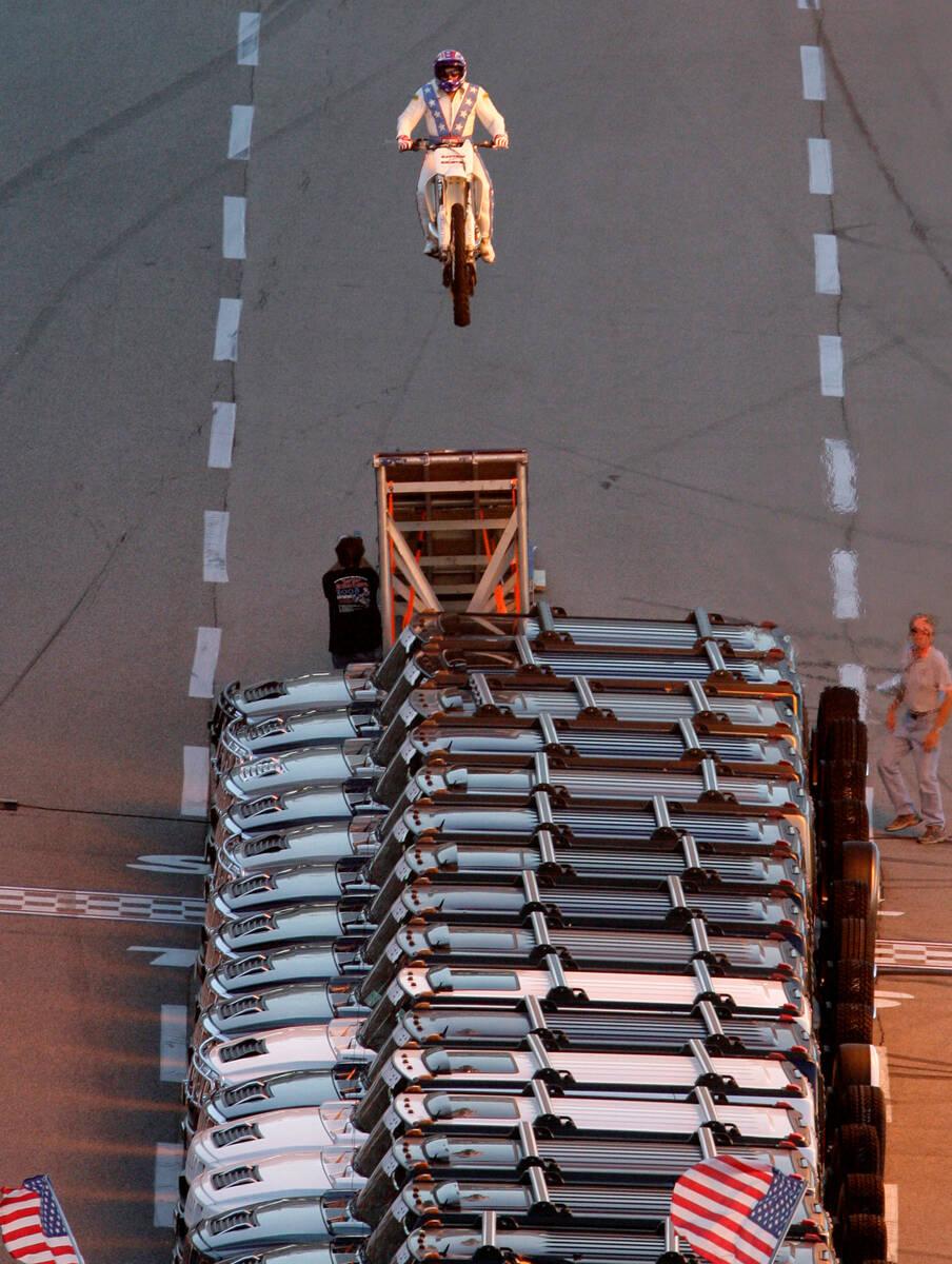 Stunt motorcycle driver Robbie Knievel successfully jumps over 21 Hummers prior to an IRL race ...