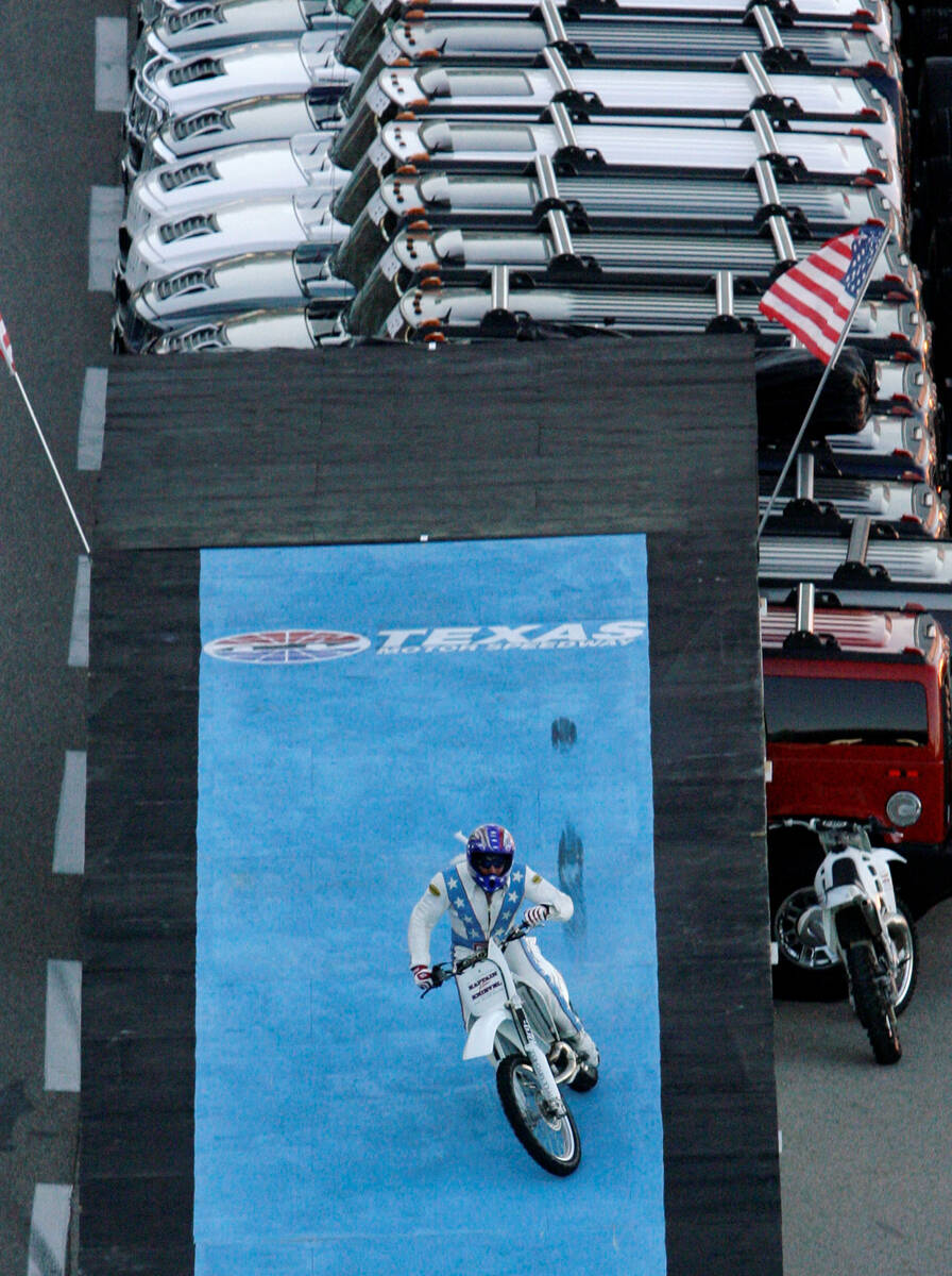 Stunt motorcycle driver Robbie Knievel lands after jumping over 21 Hummers prior to an IndyCar ...