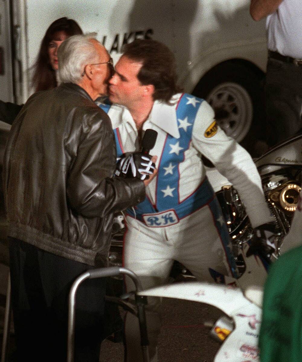 Robbie Knievel, right, kisses his daredevil father, Evel, before successfully jumping over 30 l ...