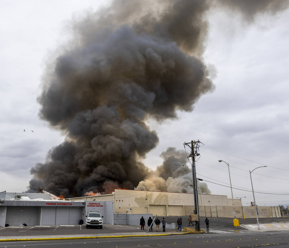 Black smoke and flames rise into the sky as Las Vegas and Clark County Firefighters work a full ...