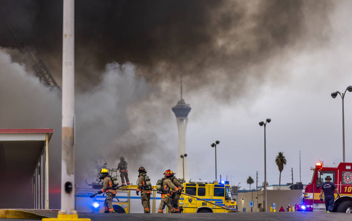 Black smoke rises into the sky as Las Vegas and Clark County Firefighters work a fully involved ...