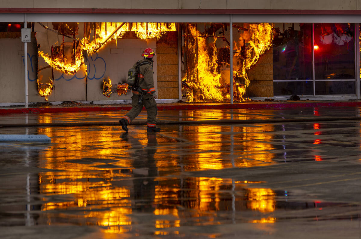 A firefighter looks to flames as Las Vegas and Clark County Firefighters work a fully involved ...