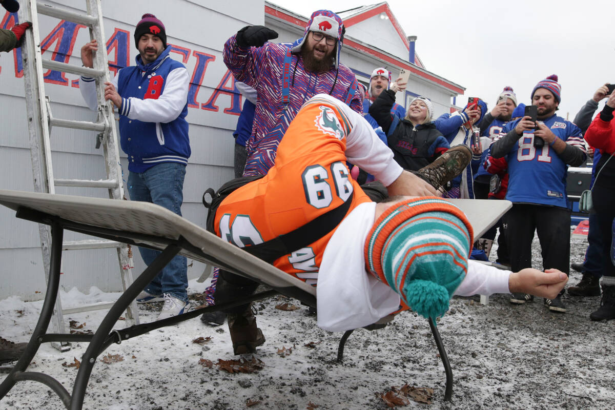 A fan crashes into a table while tailgating prior to an NFL wild-card playoff football game bet ...