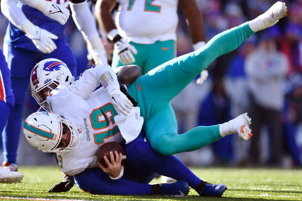 Miami Dolphins quarterback Skylar Thompson (19) is taken down by Buffalo Bills defensive end Bo ...