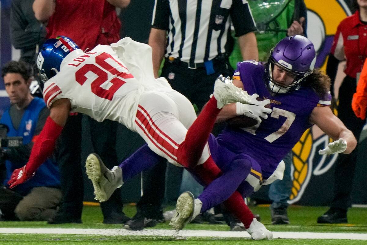 Minnesota Vikings' T.J. Hockenson is hit by New York Giants' Julian Love after catchiong a pass ...