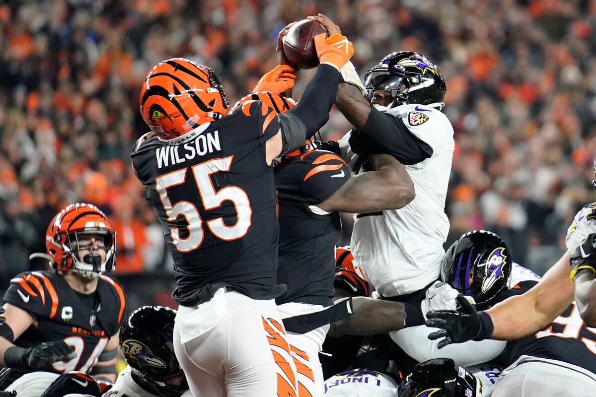 Baltimore Ravens quarterback Tyler Huntley, right, fumbles the ball as it is knocked away by Ci ...