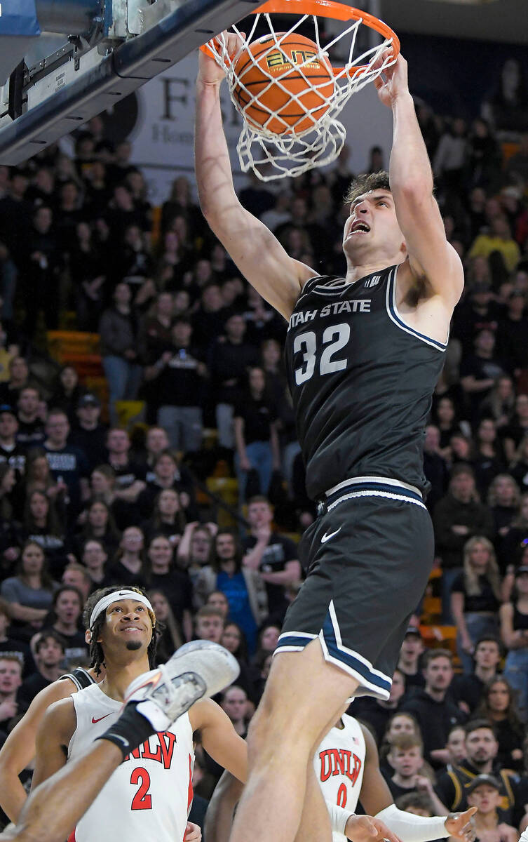 Utah State center Trevin Dorius (32) dunks the ball as UNLV guard Justin Webster (2) looks on d ...