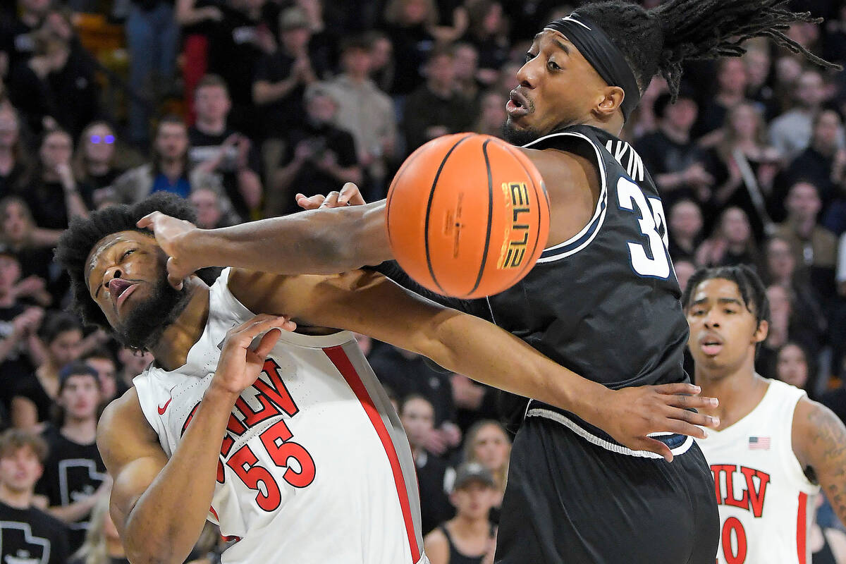 UNLV guard EJ Harkless (55) and Utah State forward Dan Akin (30) fight for a rebound during the ...