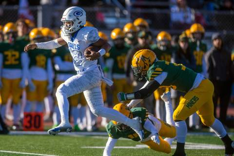 Bishop Gorman QB Micah Alejado (12) catches some air as he leaps from a tackle attempts by Bish ...