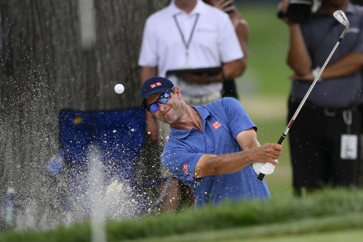 Adam Scott, of Australia, hits from a bunker toward the 14th green during the final round of th ...