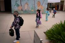 FILE - Socially distanced kindergarten students wait for their parents to pick them up on the f ...