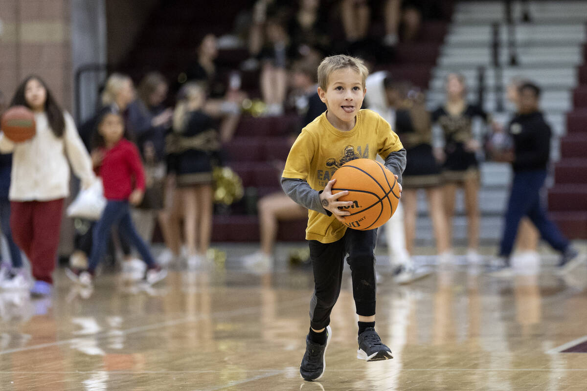 Stone Forgue, 6, runs to shoot during halftime a girls high school basketball game at Faith Lut ...