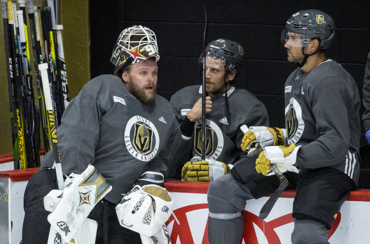 Vegas Golden Knights goaltender Robin Lehner (90, left) chats with defenseman Shea Theodore (27 ...
