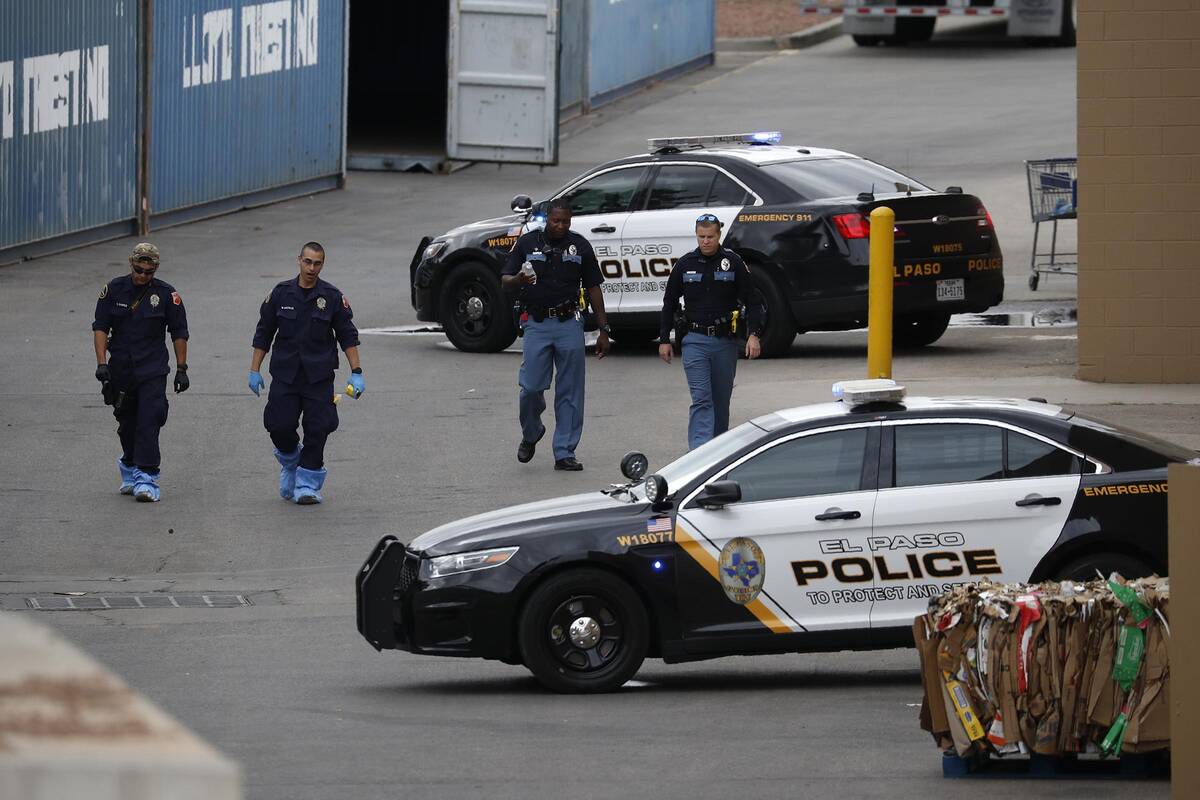 FILE - In this Aug. 6, 2019, file photo, police officers walk behind a Walmart at the scene of ...