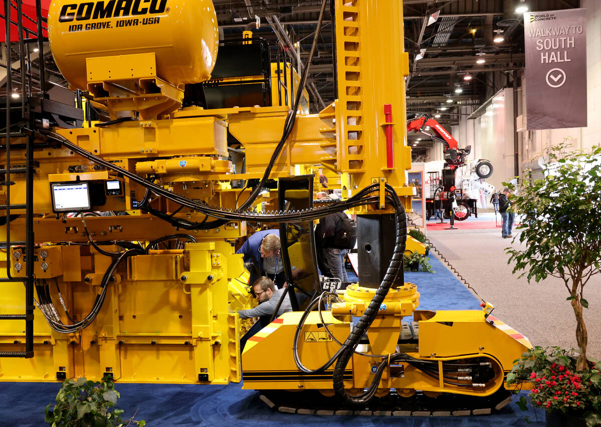 Conventioneers check out a concrete slipform paver used to make roads in the Gomaco booth on Da ...