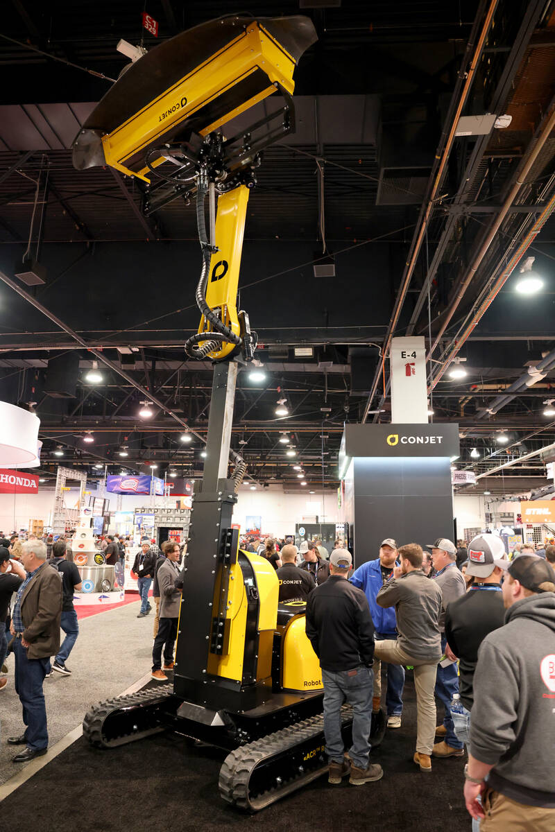 Conventioneers check out a hydro-demolition robot used for selective removal of concrete struct ...