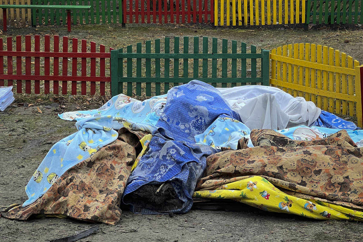 Dead bodies covered by blankets are seen in a kindergarten at the scene where a helicopter cras ...