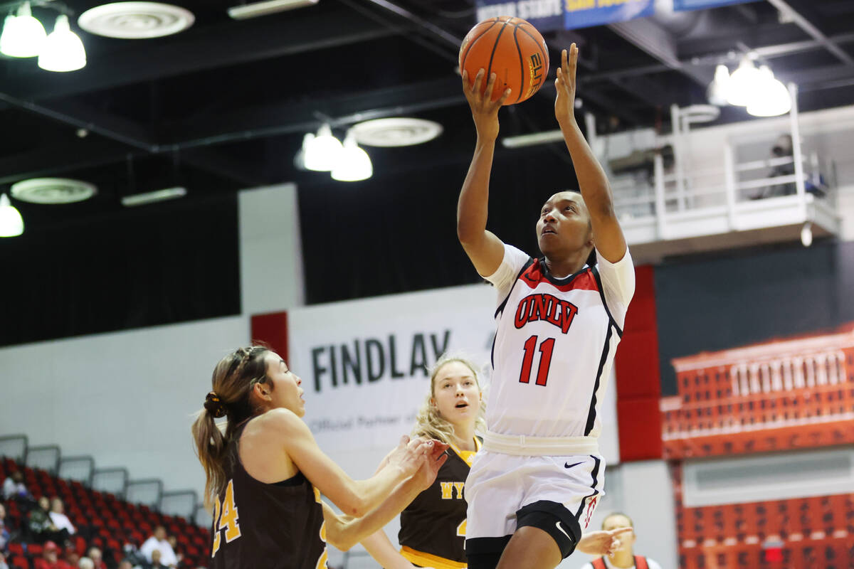 UNLV Lady Rebels guard Justice Ethridge (11) takes a shot as Wyoming Cowgirls guard Tommi Olson ...