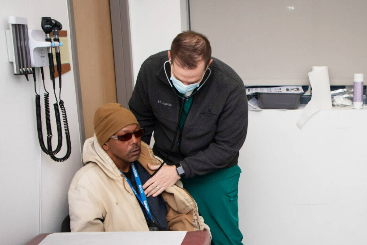 Nurse practitioner Myles Adamson, right, provides medical care to patient Anthony April on Wedn ...