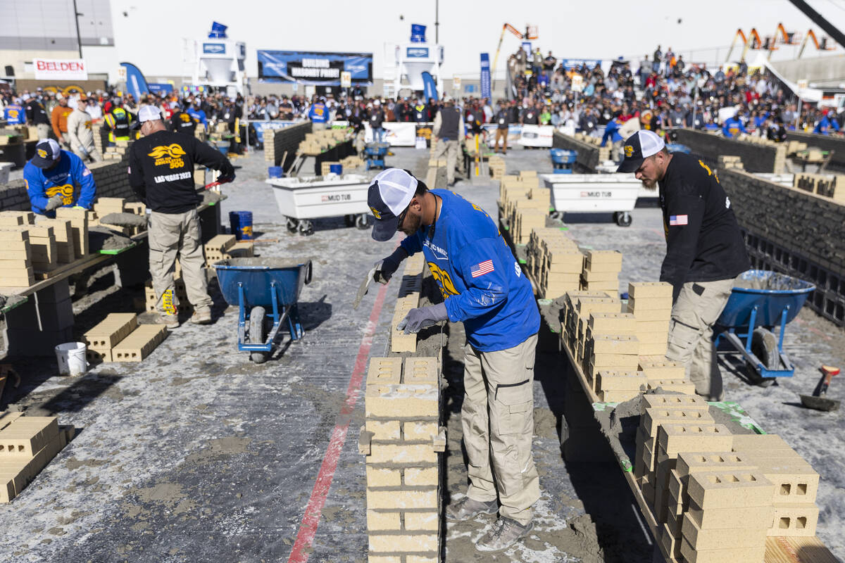 Trint Pierce, center, participates in the World of Concrete Convention bricklaying competition ...