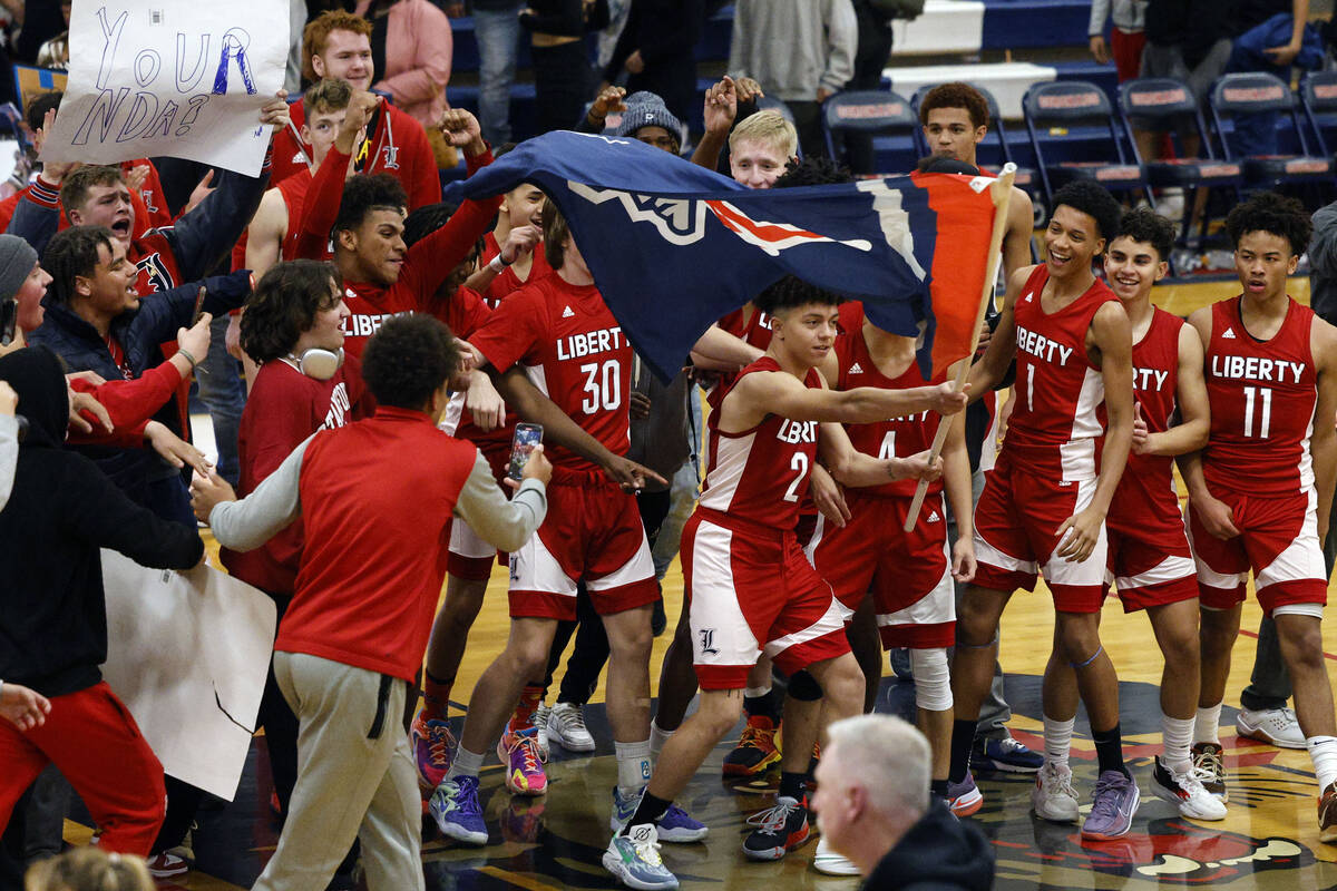 Liberty players celebrate their 72-67 victory against Coronado after overtime of a basketball g ...