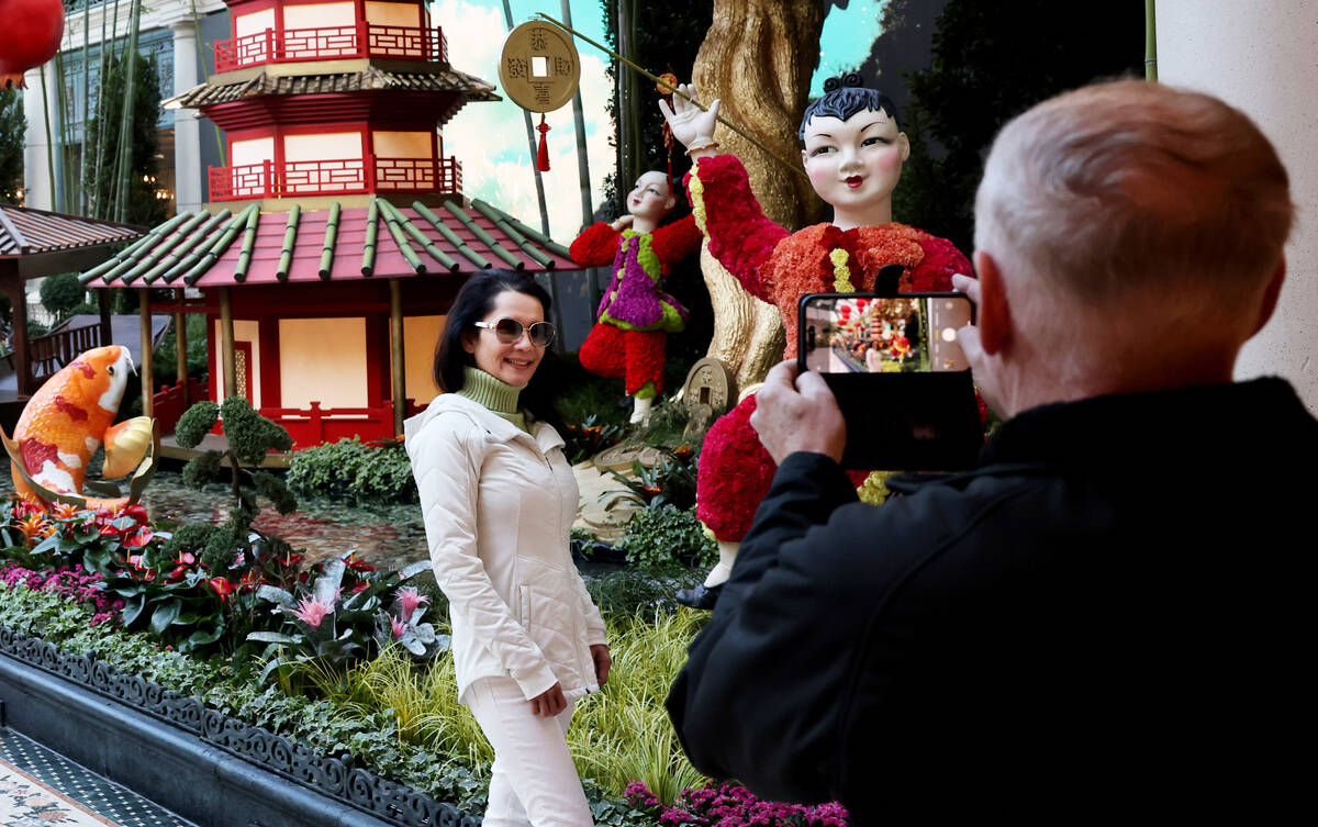 Kent Kahle of San Diego takes a photo of his wife Diana Kahle with the Year of the Rabbit displ ...