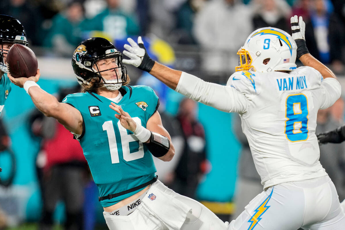 Jacksonville Jaguars quarterback Trevor Lawrence (16) tries to throw a pass under pressure by L ...
